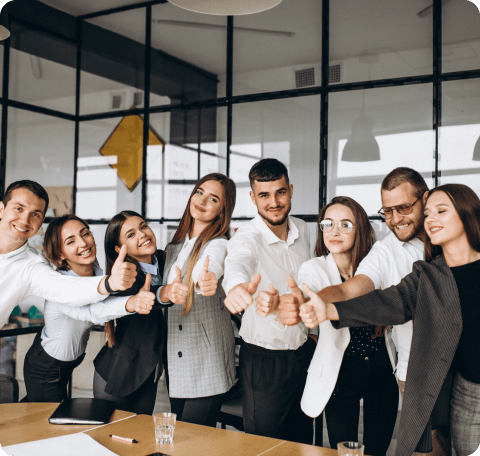 Imagen de ocho personas en una sala de reuniones celebrando y apuntando positivamente con las manos